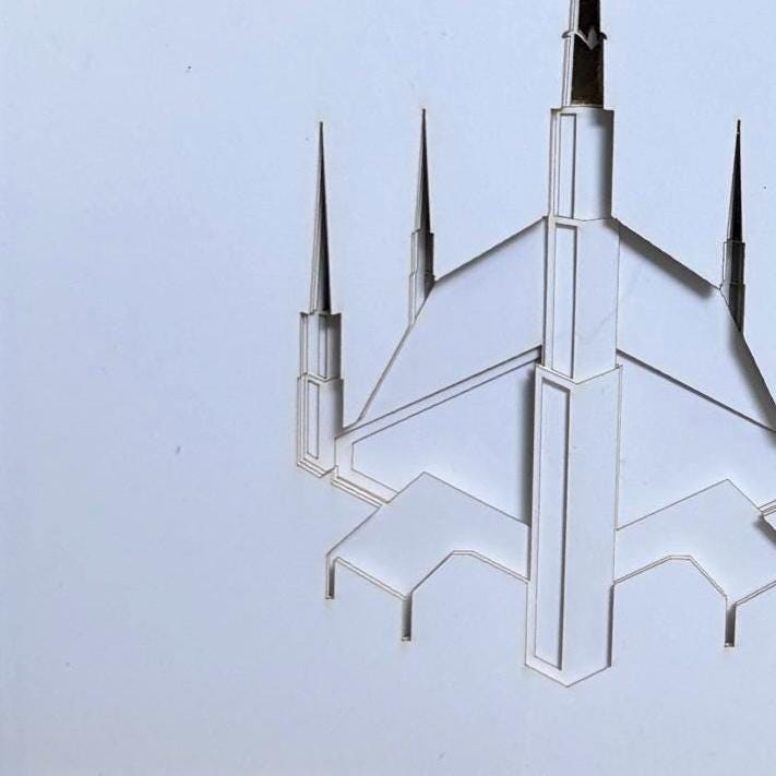 A minimalist architectural art print or laser-cut design of a cathedral spire, rendered in white and light gray tones against a pale blue background. Dallas Temple.