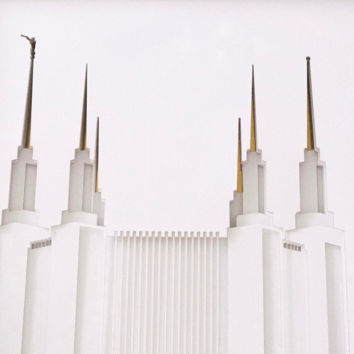 A minimalist architectural photograph of Washington DC temple with tall spires and gold-toned roof accents against a very light gray sky.